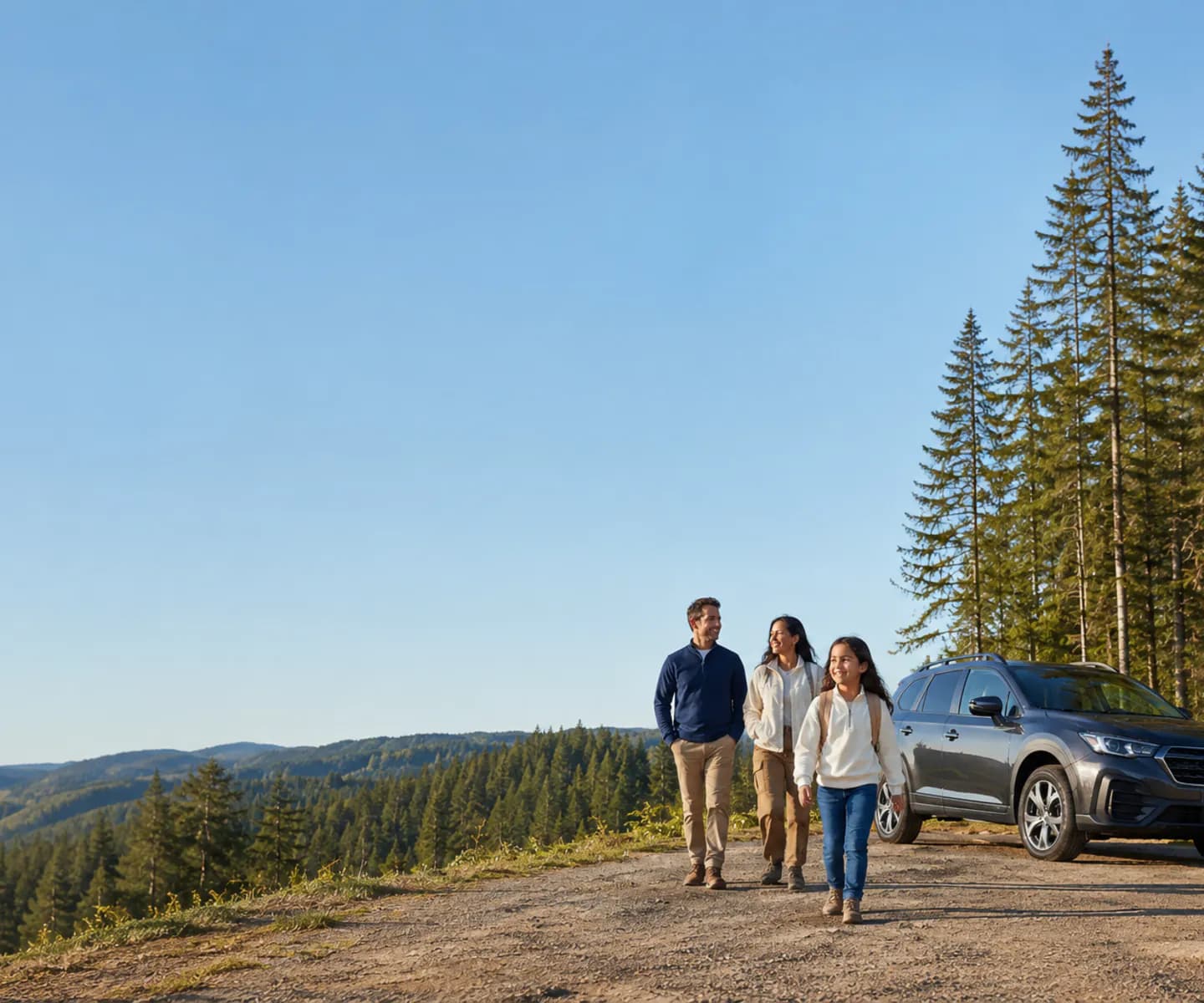 A family of three walking toward their SUV on a forest overlook